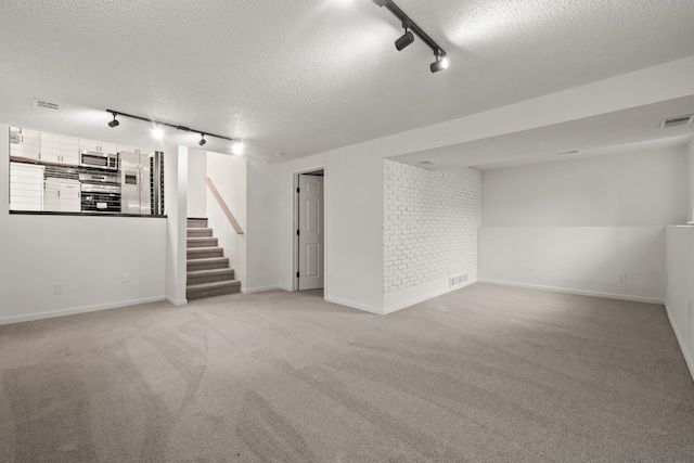 3884 Cass Elizabeth Rd, Waterford, MI 48328 - finished basement with rail lighting, a textured ceiling, stairway, and light carpet
