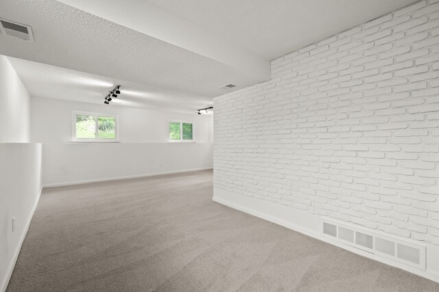 3884 Cass Elizabeth Rd, Waterford, MI 48328 - spare room with brick wall, light carpet, a textured ceiling, and track lighting