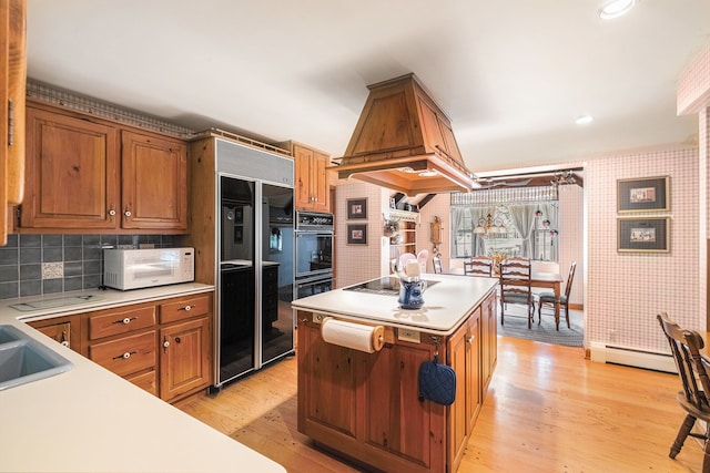 2103 E Newark Rd, Lapeer, MI 48446 - kitchen with black appliances, brown cabinets, light wood-type flooring, light countertops, and wallpapered walls