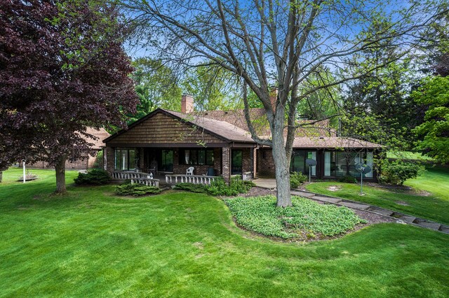 2103 E Newark Rd, Lapeer, MI 48446 - view of front facade with a front lawn, a chimney, brick siding, and covered porch
