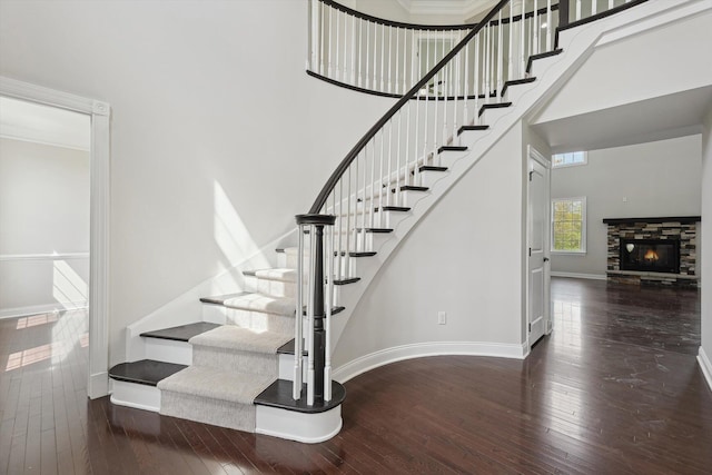 1840 Tapadera Dr, Ann Arbor, MI 48103 - stairway featuring a towering ceiling, wood-type flooring, baseboards, and a stone fireplace