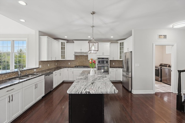 1840 Tapadera Dr, Ann Arbor, MI 48103 - kitchen featuring a sink, independent washer and dryer, stainless steel appliances, under cabinet range hood, and dark stone counters