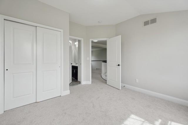 1840 Tapadera Dr, Ann Arbor, MI 48103 - unfurnished bedroom featuring light carpet, a closet, baseboards, and vaulted ceiling
