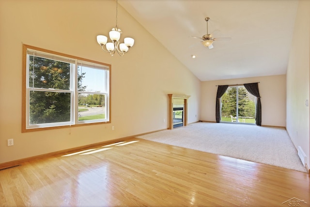 1 Sanctuary Way, Freeland, MI 48623 - unfurnished living room featuring high vaulted ceiling, a fireplace, a chandelier, wood finished floors, and baseboards
