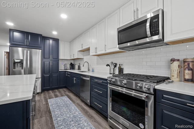 508 Chamberlain St Unit 8, Flushing, MI 48433 - kitchen featuring appliances with stainless steel finishes, blue cabinets, a sink, backsplash, and wood finished floors