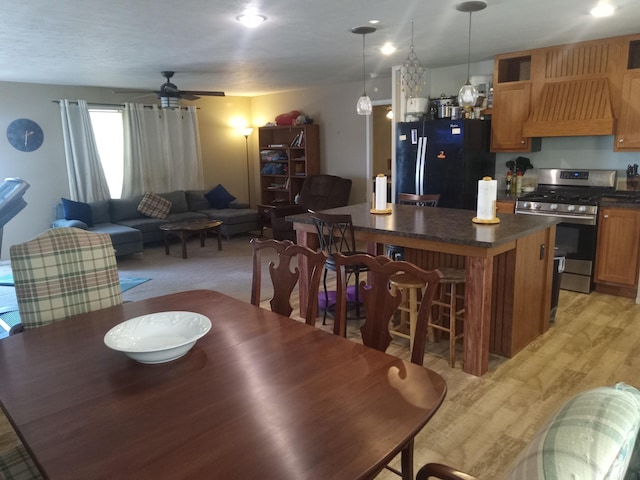 dining room with ceiling fan and light wood-style flooring
