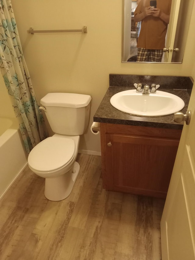 full bathroom with wood finished floors, toilet, and vanity