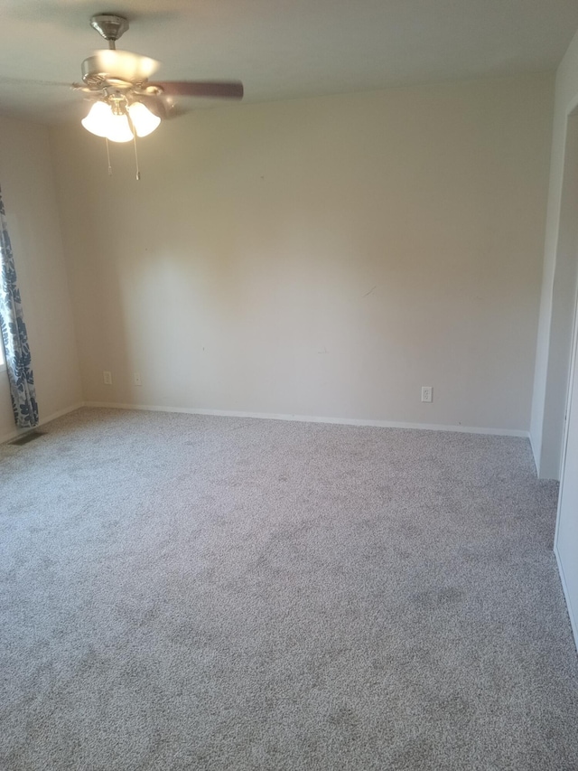 empty room featuring carpet floors, a ceiling fan, and baseboards