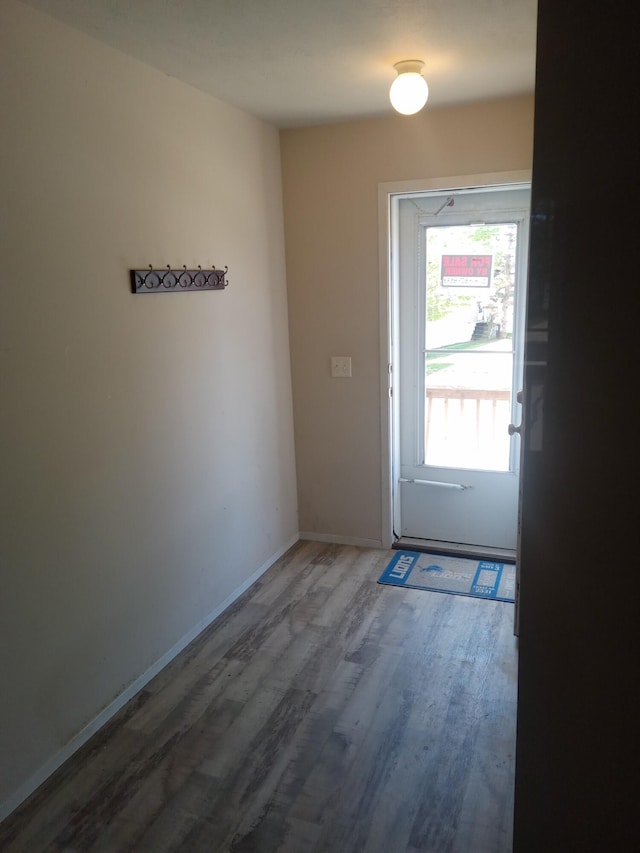 doorway featuring wood finished floors and baseboards