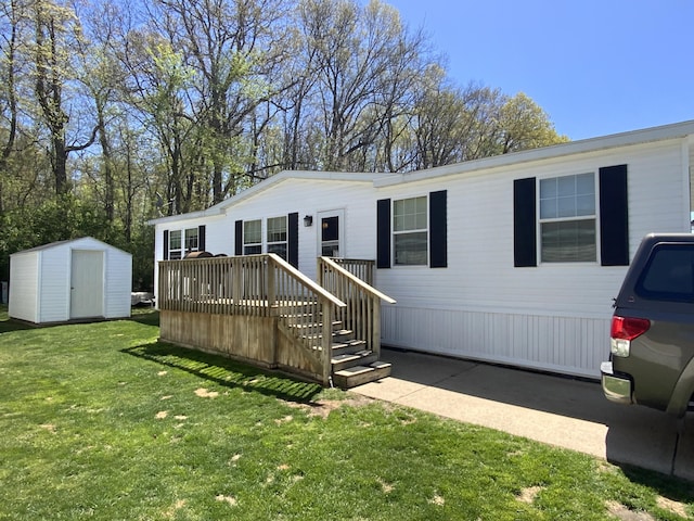 manufactured / mobile home featuring a storage shed, a deck, a front lawn, and an outbuilding