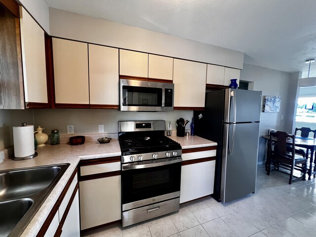304 S Ferry St Unit 7, Ludington, MI 49431 - kitchen with appliances with stainless steel finishes, a sink, light countertops, and white cabinetry