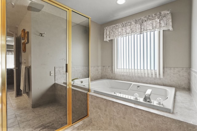 full bathroom with healthy amount of natural light, a jetted tub, a stall shower, and tile patterned floors