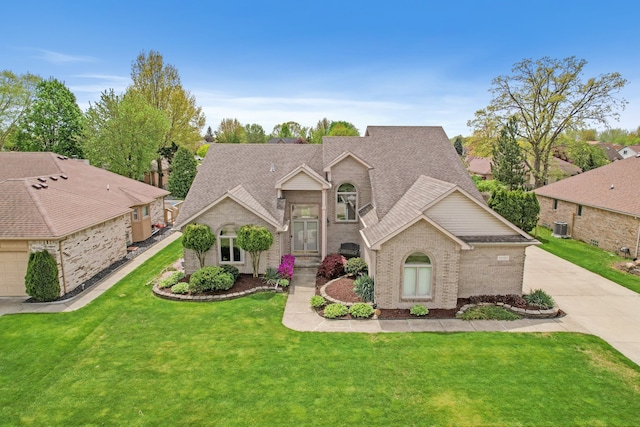 traditional-style home featuring brick siding, a shingled roof, a front lawn, central AC unit, and driveway
