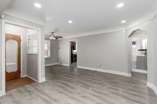 1526 S Gulley Rd, Dearborn Heights, MI 48125 - unfurnished living room featuring a ceiling fan, arched walkways, recessed lighting, baseboards, and light wood-style floors