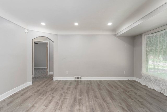 1526 S Gulley Rd, Dearborn Heights, MI 48125 - empty room with light wood-style flooring, arched walkways, recessed lighting, and baseboards