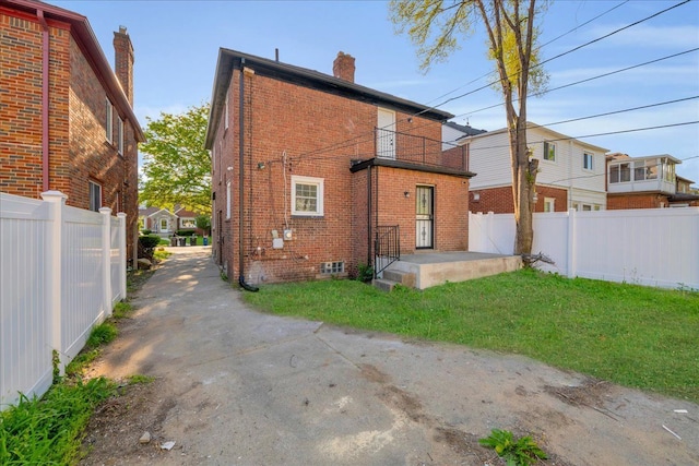 17550 Ohio St, Detroit, MI 48221 - rear view of house with a balcony, brick siding, a chimney, and driveway