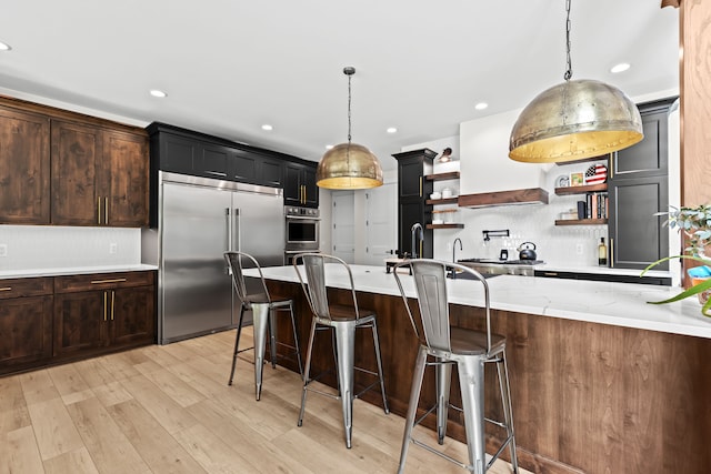 kitchen featuring stainless steel appliances, open shelves, backsplash, pendant lighting, and custom range hood