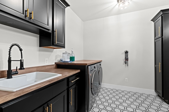 laundry area featuring cabinet space, washer and clothes dryer, and baseboards