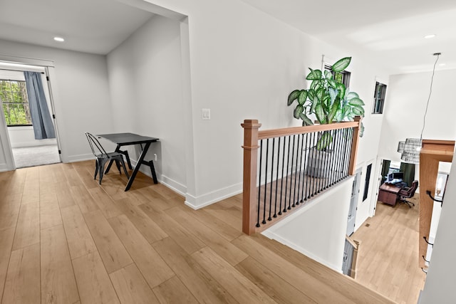 hallway featuring light wood finished floors, recessed lighting, an upstairs landing, and baseboards
