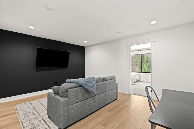 living room with light wood-type flooring, recessed lighting, and baseboards