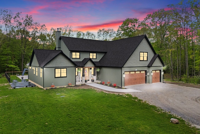 modern farmhouse featuring driveway, a chimney, a front yard, and a porch