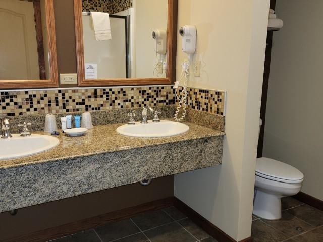 2400 Troon S, Bellaire, MI 49615 - bathroom with baseboards, toilet, tile patterned floors, and dual sinks