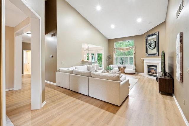 42259 White Hart Blvd, Canton, MI 48188 - living room with light wood-style floors, a fireplace with flush hearth, baseboards, high vaulted ceiling, and recessed lighting