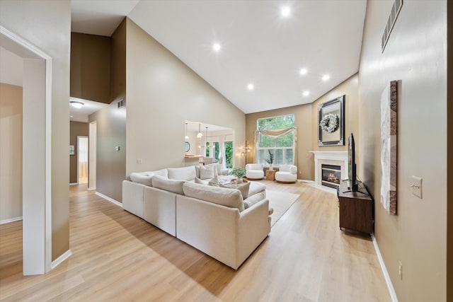 42259 White Hart Blvd, Canton, MI 48188 - living area with high vaulted ceiling, light wood-style flooring, baseboards, a fireplace with flush hearth, and recessed lighting