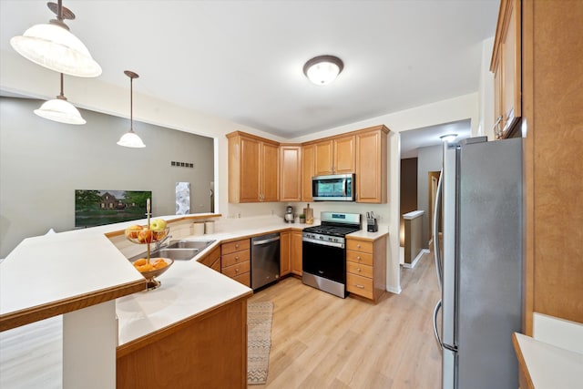 42259 White Hart Blvd, Canton, MI 48188 - kitchen featuring stainless steel appliances, a peninsula, light wood-style flooring, a sink, and light countertops