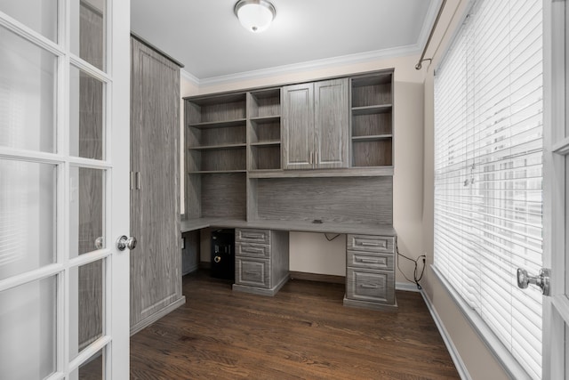 unfurnished office featuring ornamental molding, dark wood-type flooring, baseboards, and built in study area