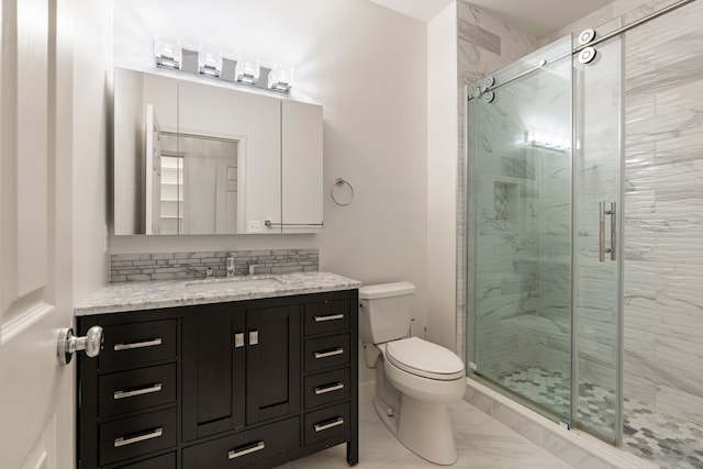 full bath with marble look tile flooring, toilet, a shower stall, and vanity