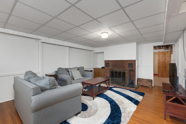 212 W Mckay St, Saline, MI 48176 - living room with wood finished floors, a drop ceiling, and a brick fireplace
