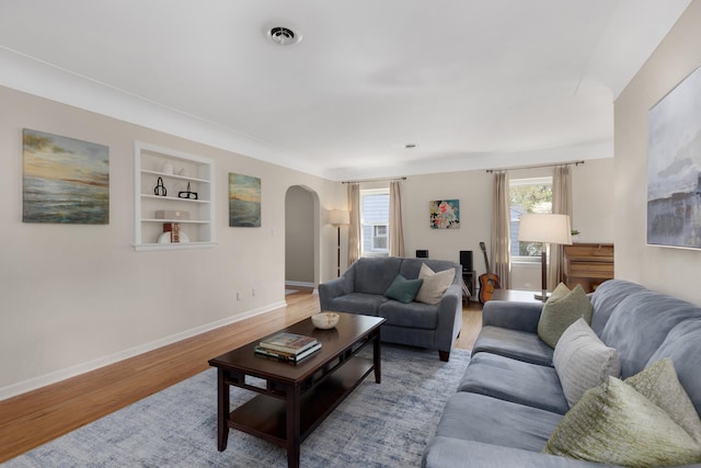 212 W Mckay St, Saline, MI 48176 - living room with arched walkways, built in shelves, wood finished floors, and baseboards
