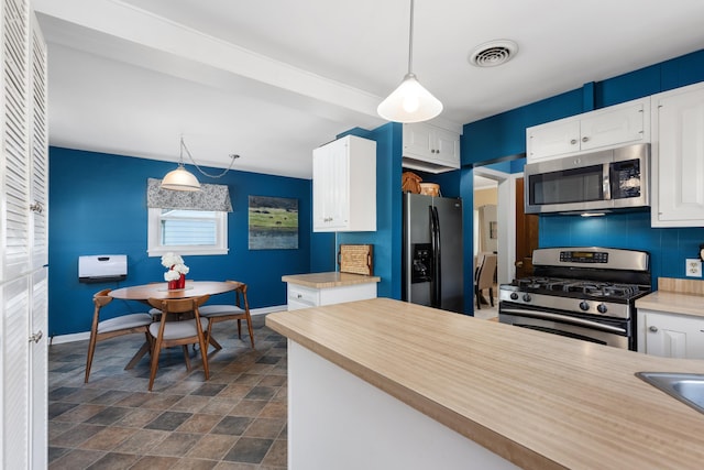 212 W Mckay St, Saline, MI 48176 - kitchen with stainless steel appliances, baseboards, stone finish floors, white cabinets, and tasteful backsplash