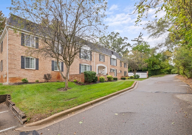 view of front of house featuring brick siding and a front yard