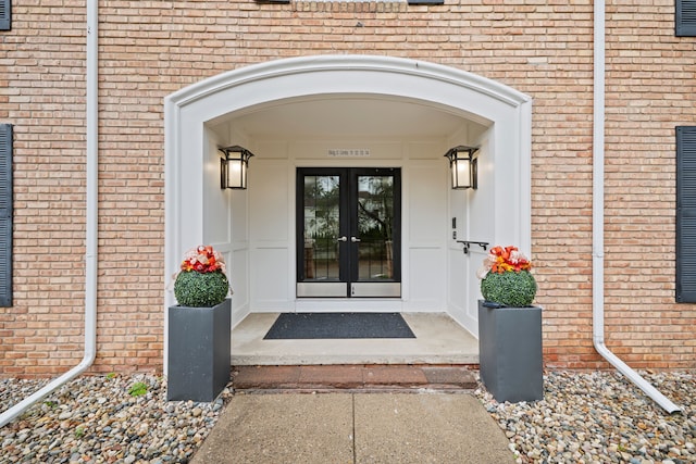 view of exterior entry with french doors and brick siding