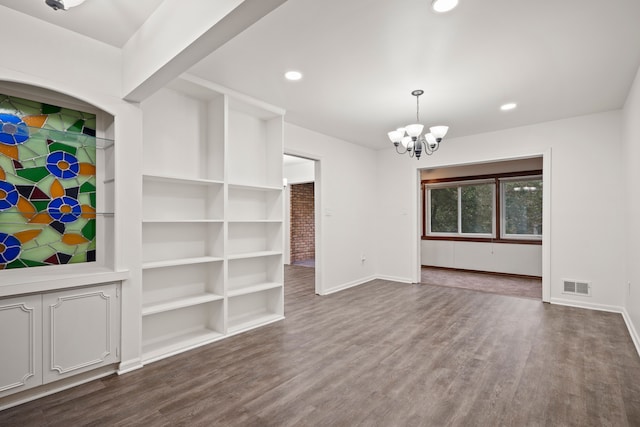 unfurnished living room with baseboards, a chandelier, dark wood-type flooring, and recessed lighting