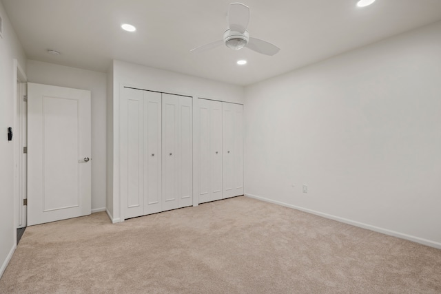 unfurnished bedroom with multiple closets, carpet floors, recessed lighting, baseboards, and a ceiling fan