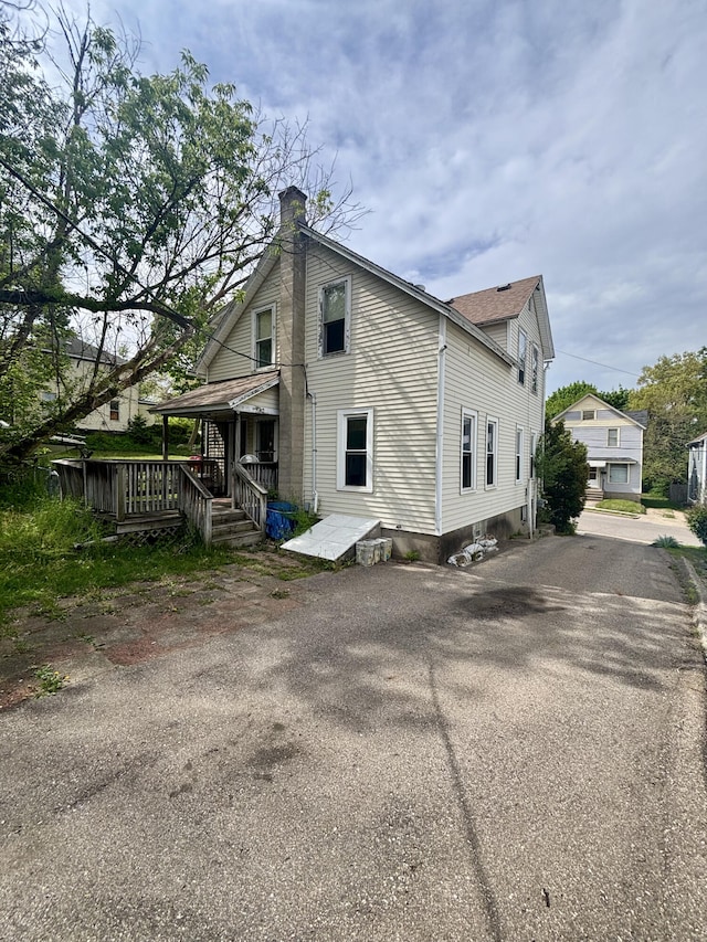 view of home's exterior featuring driveway and a chimney