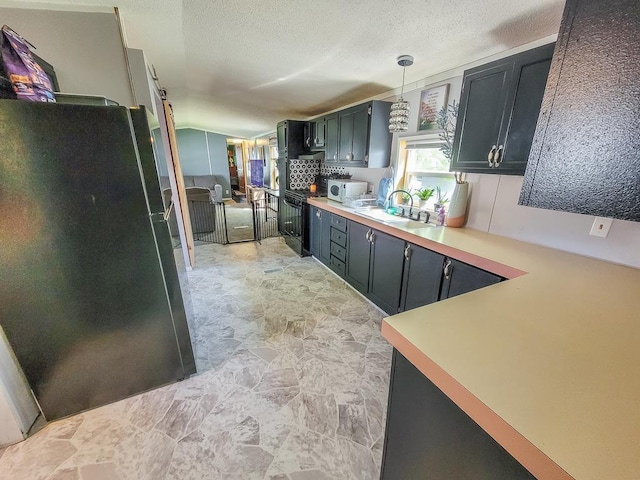 411 S Grover Ave, Alma, MI 48801 - kitchen featuring black appliances, a sink, light countertops, hanging light fixtures, and a textured ceiling