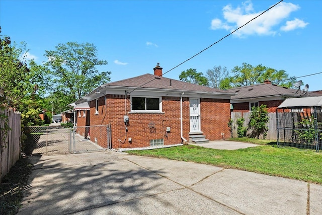 rear view of house featuring entry steps, a gate, a chimney, and brick siding