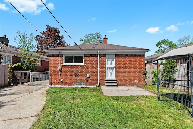 back of house with entry steps, a chimney, a gate, brick siding, and concrete driveway
