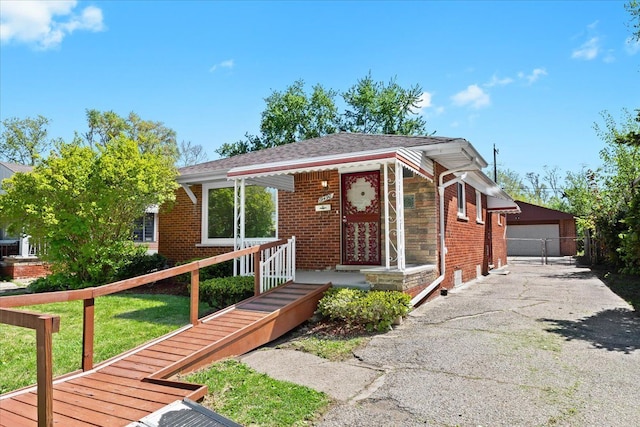 view of front of property featuring an outbuilding, brick siding, and a detached garage