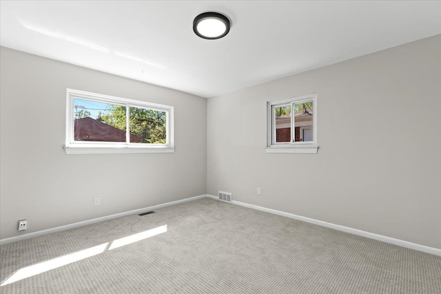 unfurnished room featuring carpet floors, plenty of natural light, and baseboards