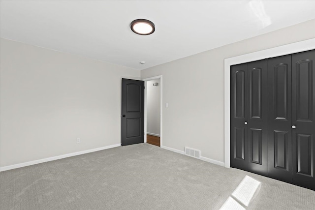 unfurnished bedroom featuring carpet flooring, baseboards, and a closet
