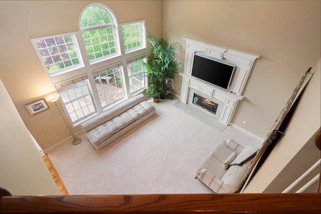1433 Bicentennial Pkwy, Ann Arbor, MI 48108 - carpeted living area featuring a fireplace with flush hearth, a towering ceiling, and baseboards
