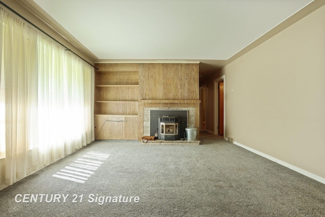 1415 Coolidge Ave, Saginaw, MI 48638 - unfurnished living room with a wood stove, carpet, and baseboards