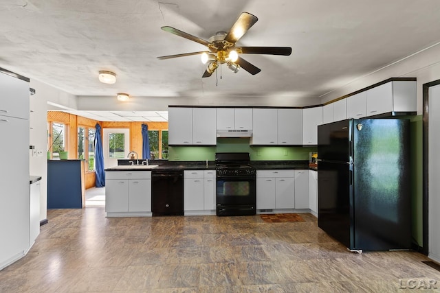 601 N Occidental Rd, Tecumseh, MI 49286 - kitchen with black appliances, under cabinet range hood, dark countertops, ceiling fan, and white cabinetry