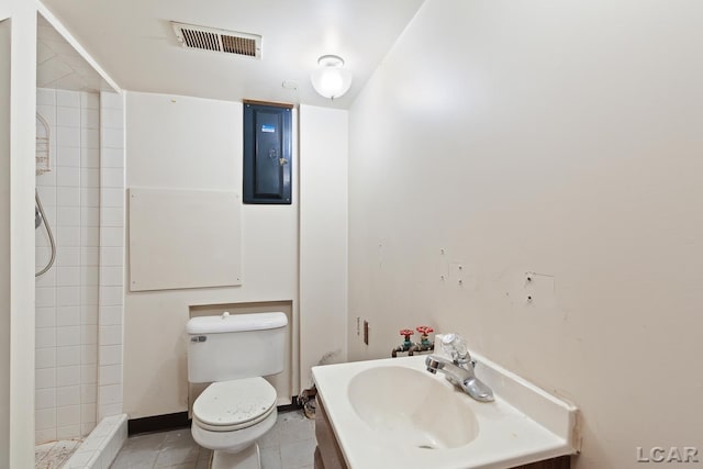 601 N Occidental Rd, Tecumseh, MI 49286 - bathroom featuring toilet, tiled shower, vanity, electric panel, and tile patterned floors
