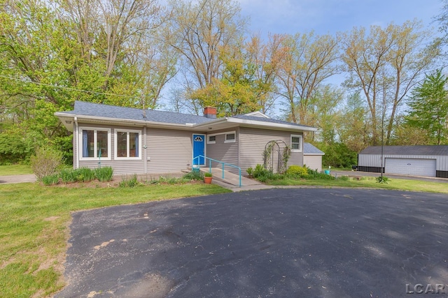 601 N Occidental Rd, Tecumseh, MI 49286 - view of front facade with a detached garage, an outdoor structure, a chimney, and a front lawn